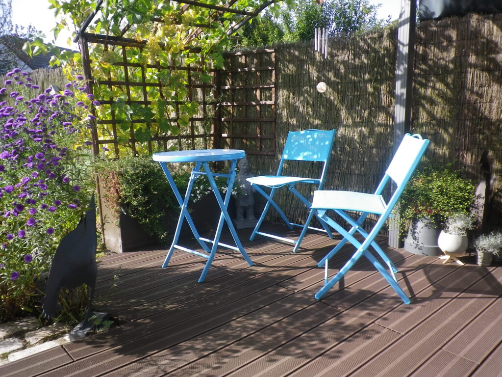 Harmonisation d'espace : Deux chaises pliantes bleues sur une terrasse en bois.